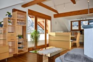a living room with wooden furniture and a glass table at Großzügiges Appartment mit Balkon im Herzen von Tirol in Umhausen