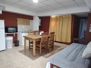 a room with a table and chairs and a kitchen at Complejo de Cabaña con pileta CABLE A TIERRA Cabaña Blend in San Rafael