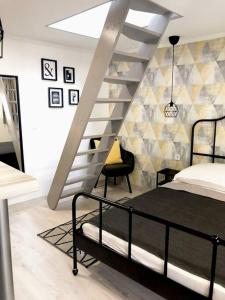 1 dormitorio con 1 cama y una escalera en una habitación en Casa Tibor, en Hajdúszoboszló