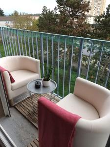 een balkon met 2 stoelen en een salontafel bij JIYARA PROCHE CENTRE Ville in Belfort