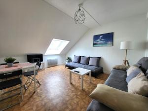 uma sala de estar com um sofá e uma mesa em St-Quentin-en-Yvelines Plusieurs appartements avec parking em Trappes