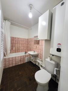 uma casa de banho com um WC e um lavatório em St-Quentin-en-Yvelines Plusieurs appartements avec parking em Trappes