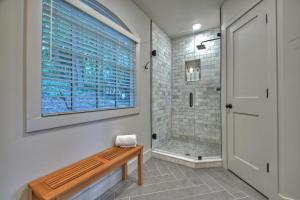 a bathroom with a shower and a wooden bench at Piney Cove in Blue Ridge +49 photos