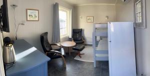 a small room with a bunk bed and a table and chairs at Oppmyre Camping in Myre