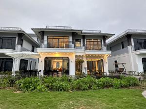 uma grande casa branca com um relvado em frente em KAM's Home em Quang Ninh