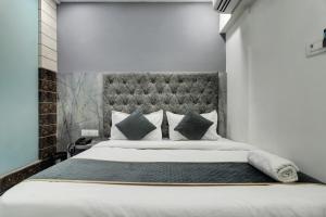 a bedroom with a large bed with a large headboard at HOTEL BB HOUSE in Mumbai