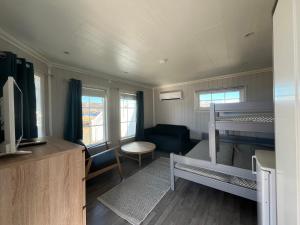 Oppmyre Camping في Myre: غرفة صغيرة مع سرير بطابقين وأريكة
