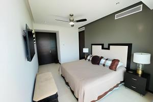 une chambre avec un lit et un ventilateur de plafond dans l'établissement Condominio con las mejores vistas de la bahía, à Bucerías 22 autres photos