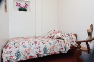 a bedroom with a bed with a floral bedspread at Green Heart Homestay in Nuwara Eliya