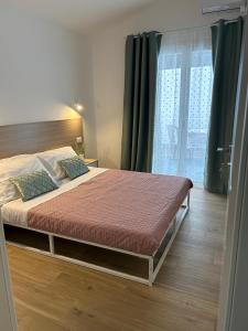 um quarto com uma cama grande e uma janela grande em Etna sicula em San Giovanni la Punta