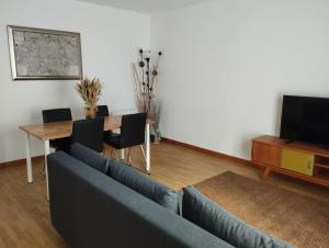 a living room with a couch and a table and a tv at Appartement calme proche Paris in Villiers-sur-Marne