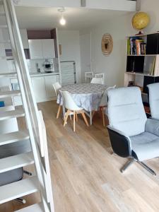 - une cuisine et une salle à manger avec une table et des chaises dans l'établissement Duplex face océan T2 + mezzanine à Bretignolles sur mer, à Bretignolles-sur-Mer
