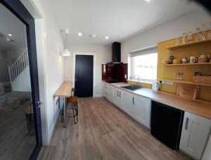 a kitchen with white cabinets and a wooden counter top at PatsView Lodge in Donegal
