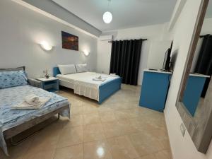 1 dormitorio con 1 cama y TV en Itaka Hotel, en Lukovë