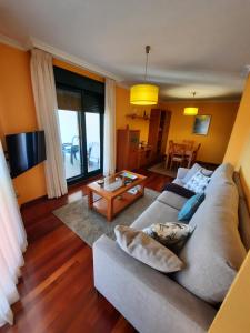salon z kanapą i stołem w obiekcie Apartamento en Beiramar w mieście O Grove