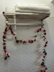 a towel rack with flowers on the wall at The kioka gardens with Wifi and parking in Nanyuki