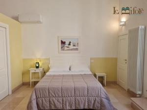 a bedroom with a bed and two small tables at Le Bifore B&B in Molfetta