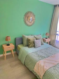 1 dormitorio con cama y espejo en la pared en b- Appartement lumineux proche velizy bis, en Meudon