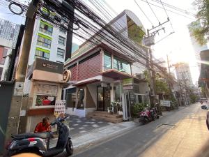 a scooter parked in front of a building on a street at Silom Forest Exclusive Residence in Bangkok