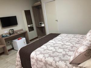 Habitación de hotel con cama y TV en Ingá Apart & Suites en Puerto Iguazú