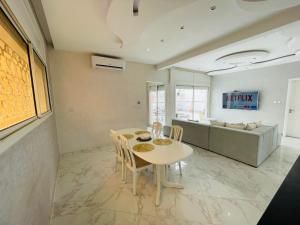 - une salle à manger avec une table et un canapé dans l'établissement Luxe appartement vc grand terrasse ( villa ), à Safi