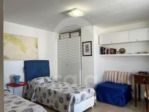 um quarto com uma cama, uma cadeira e uma mesa em Il Timone em Porto Cesareo