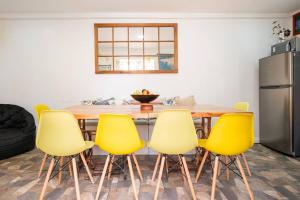 a kitchen with a wooden table and yellow chairs at Casa Fibonacci in Valparaíso