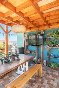 uma sala de jantar com uma mesa de madeira e uma televisão em Casa Fibonacci em Valparaíso