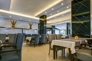 Kleopatra Arsi Hotel في ألانيا: غرفة طعام مع طاولات وكراسي في مطعم