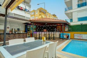 a patio with a table and chairs and a swimming pool at Kleopatra Arsi Hotel in Alanya