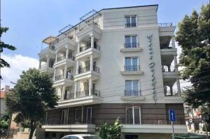 a white building with balconies on the side of it at Апартамент за гости ДЕНИЦА in Obzor