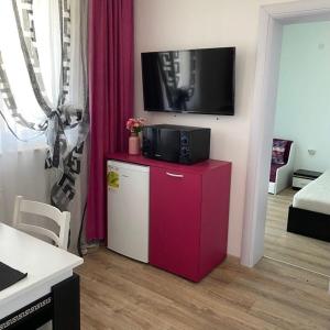 a living room with a tv on top of a cabinet at Апартамент за гости ДЕНИЦА in Obzor