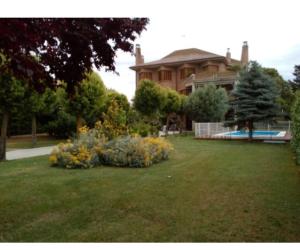 a house with a yard with flowers in front of it at Casa Gilgar Olite in Olite