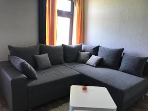 a living room with a gray couch and a table at Ferienwohnung in Friedrichskoog mit Großem Garten in Friedrichskoog