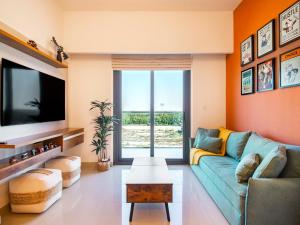 sala de estar con sofá azul y TV en Luxury 1-Bedroom Hideaway In Meydan en Dubái