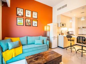sala de estar con sofá azul y cocina en Luxury 1-Bedroom Hideaway In Meydan en Dubái