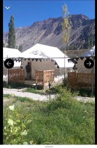 a man standing in front of a tent with a mountain at Nubra ethnic camp in Nubra