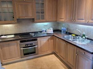 a kitchen with wooden cabinets and a sink at Palm Oasis - Time Sharing in Las Palmas de Gran Canaria