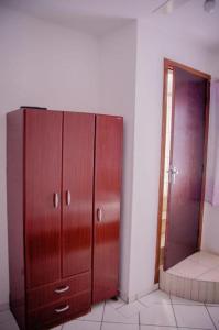 a large wooden cabinet in a room with a door at Hotel Silva Votorantim próximo a rodoviária ao hospital Santo Antônio e a Praça de eventos Leci Campos - By UP Hotel in Votorantim