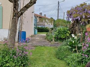 a garden with purple flowers and a house at Chez Soizic et Patrick in Bords