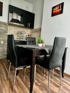 ein Esszimmer mit einem Tisch und schwarzen Stühlen in der Unterkunft Apartment Alex in Sandanski