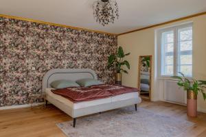 a bedroom with a bed with a floral wallpaper at Schloss Zingst in Zingst