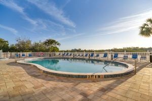 una grande piscina con recinzione e palma di Sunny Indian Shores Condo with Balcony and Views! a Clearwater Beach