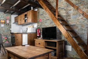 a kitchen with a wooden table with a tv on it at DieAna Alojamento Redondo in Redondo