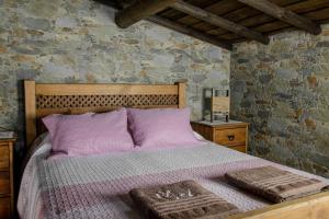 a bedroom with a bed with purple sheets and pillows at DieAna Alojamento Redondo in Redondo