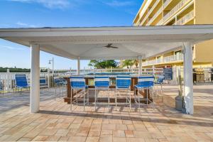 un tavolo e sedie sotto un padiglione su una passerella di Sunny Indian Shores Condo with Balcony and Views! a Clearwater Beach