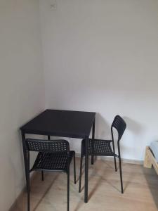 uma mesa preta e duas cadeiras num quarto em Pokoje u Lucyny 