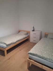 2 camas individuais num quarto com uma cómoda em Pokoje u Lucyny 