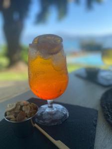 un vaso de zumo de naranja junto a un tazón de nueces en Hotel Marina del Lago , Colbún, en Rota