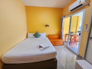 1 dormitorio con 1 cama y balcón en ลิตเติ้ลโฮม ที่พักเพชรบุรี, en Phetchaburi